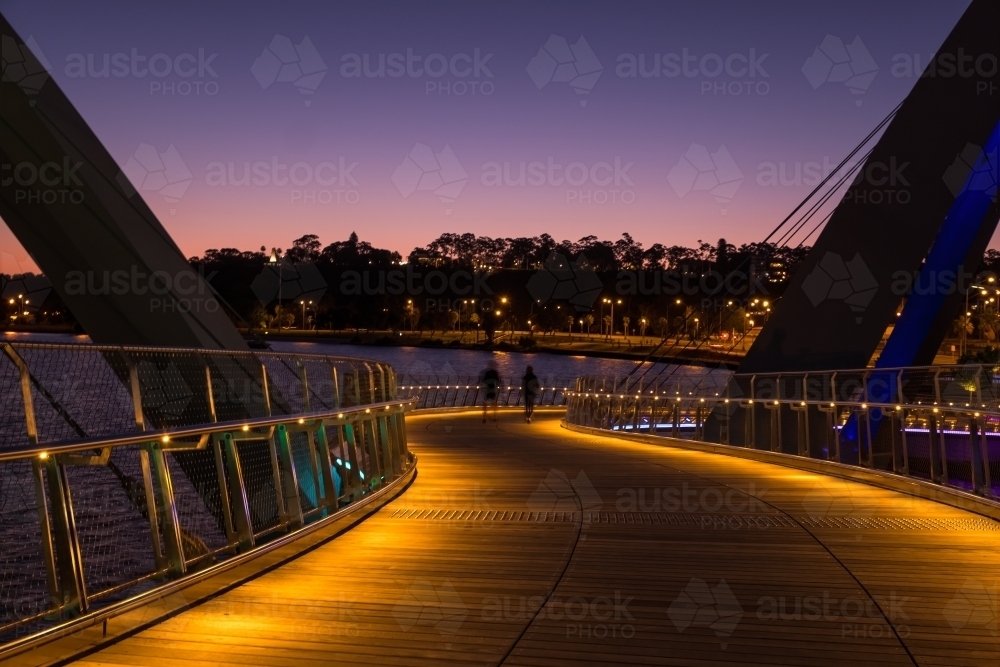 Twilight scene on bridge with two people walking at Elizabeth Quay - Australian Stock Image