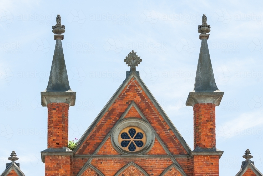 Twin spires and red brickwork at the top a church facade - Australian Stock Image