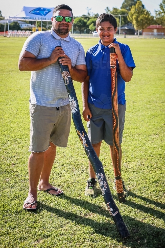 Two aboriginal males standing holding didgeridoo - Australian Stock Image