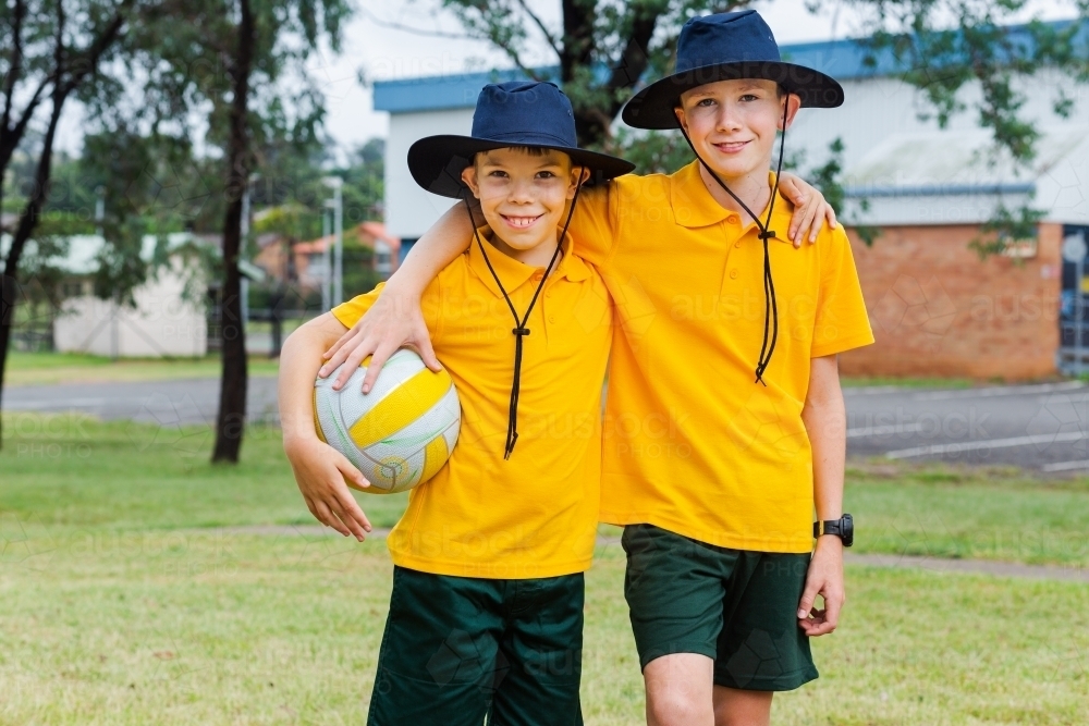 Two Australian kids in school uniform with a ball - Australian Stock Image