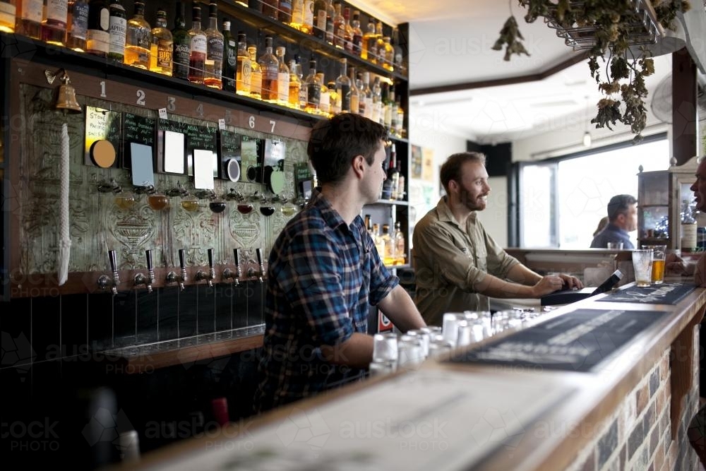 Two bartenders behind the bar at local craft beer bar - Australian Stock Image
