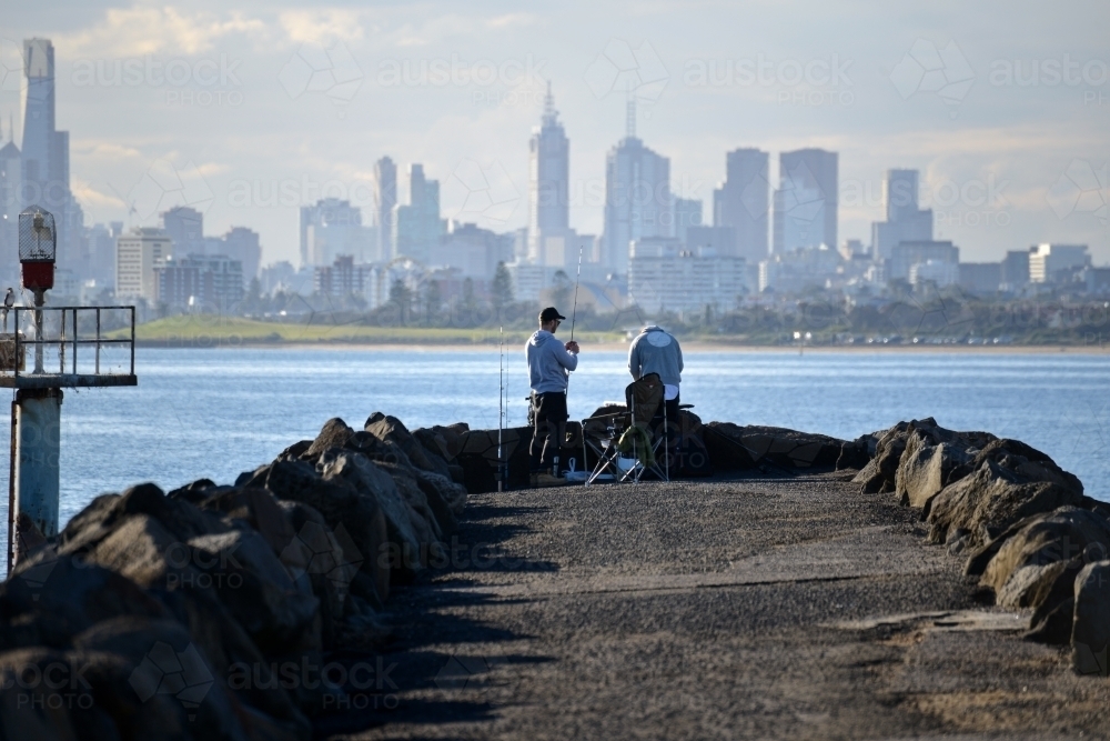 Image of Two blokes fishing at the end of a pier with the