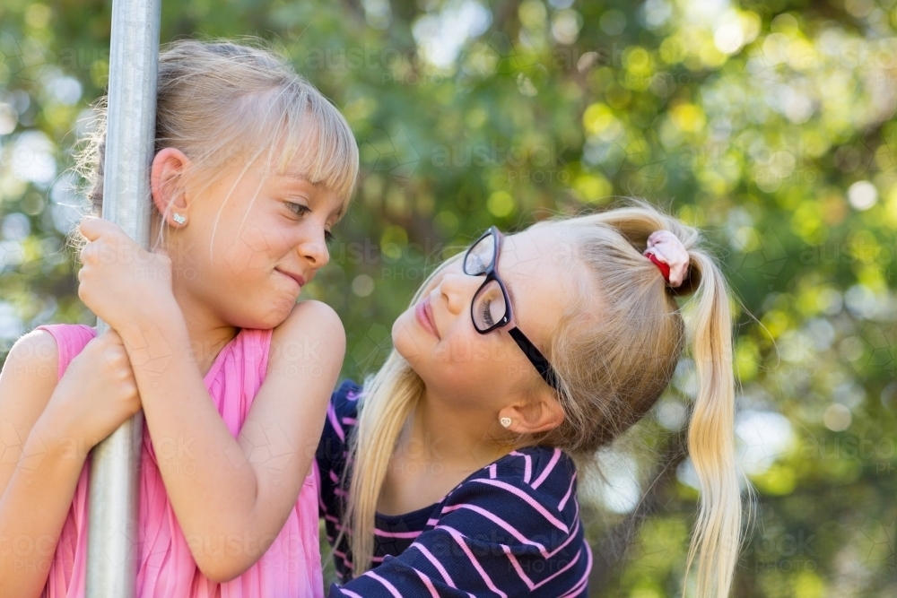 Two blonde girls looking at each other - Australian Stock Image