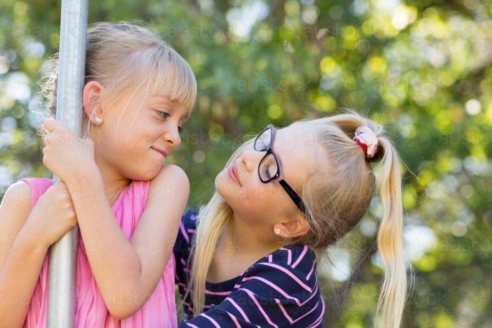 Two blonde girls looking at each other - Australian Stock Image