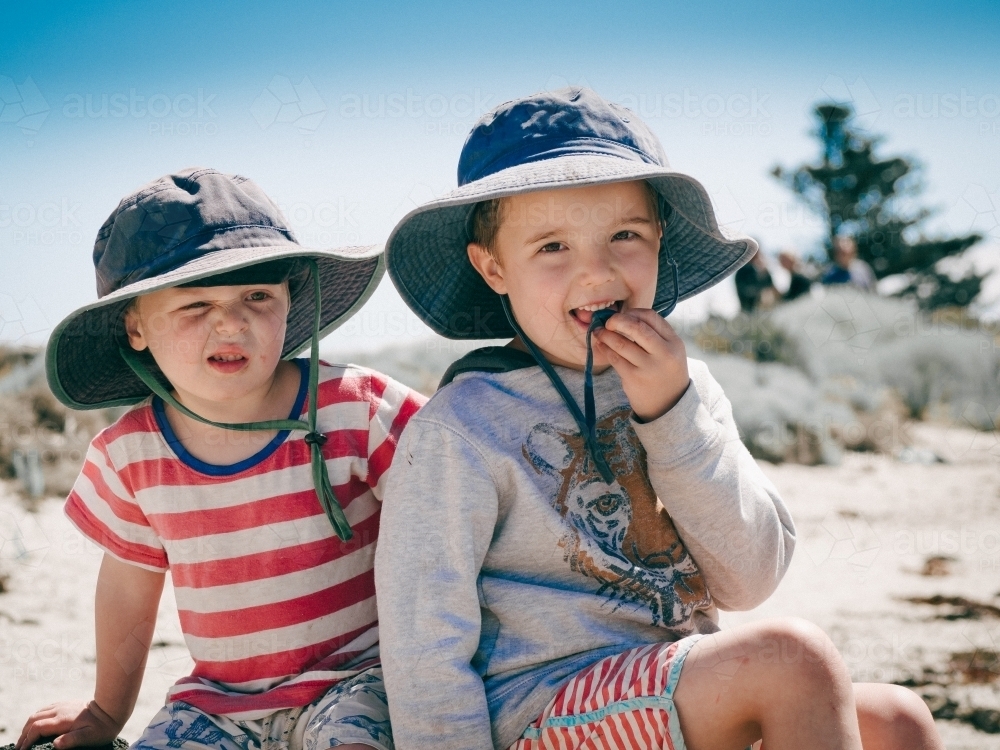 Two boys in hats at the beach - Australian Stock Image