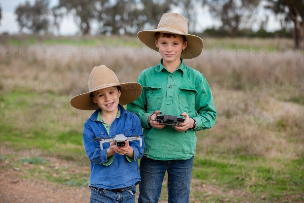 Two boys using a drone on a farm - Australian Stock Image