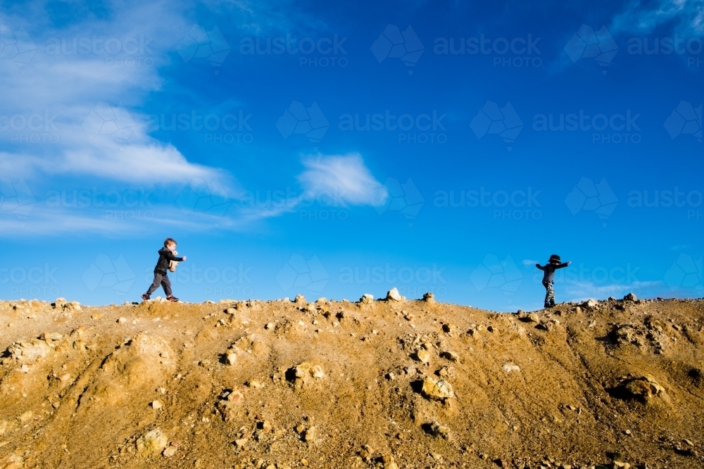 Two boys walking along a dam wall - Australian Stock Image