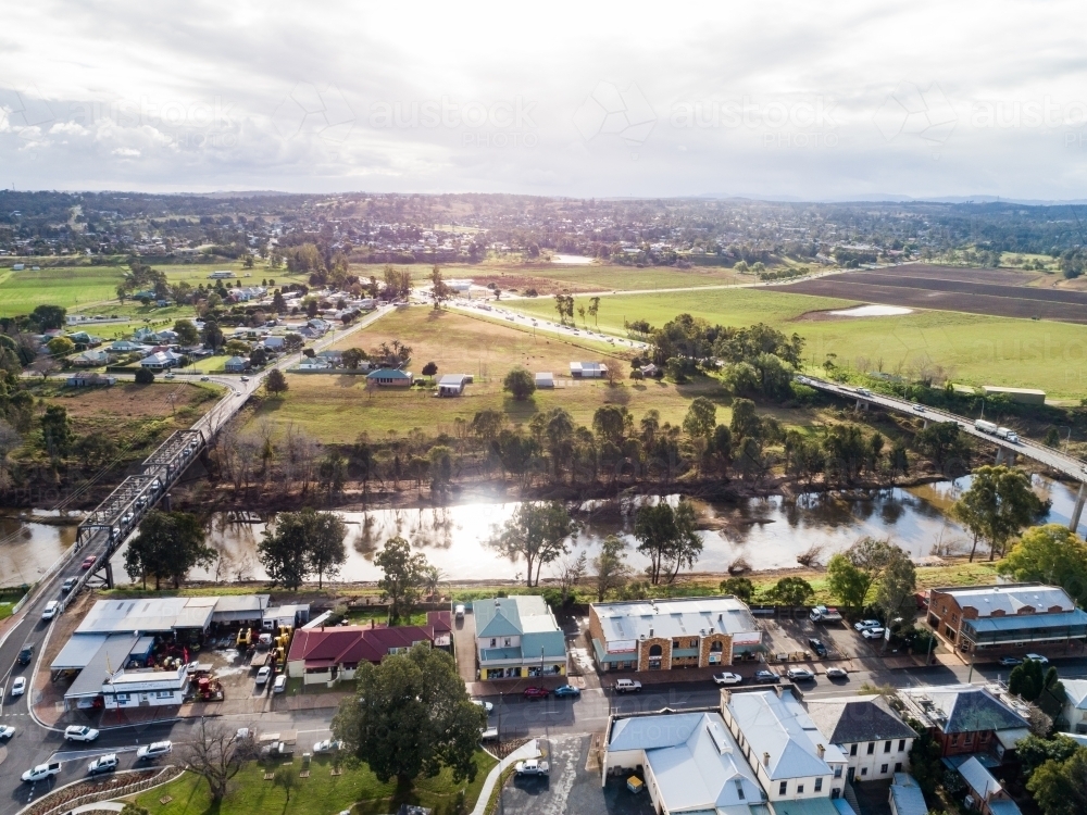 Two bridges across Hunter river in Singleton on sunlit day with town on one side - Australian Stock Image