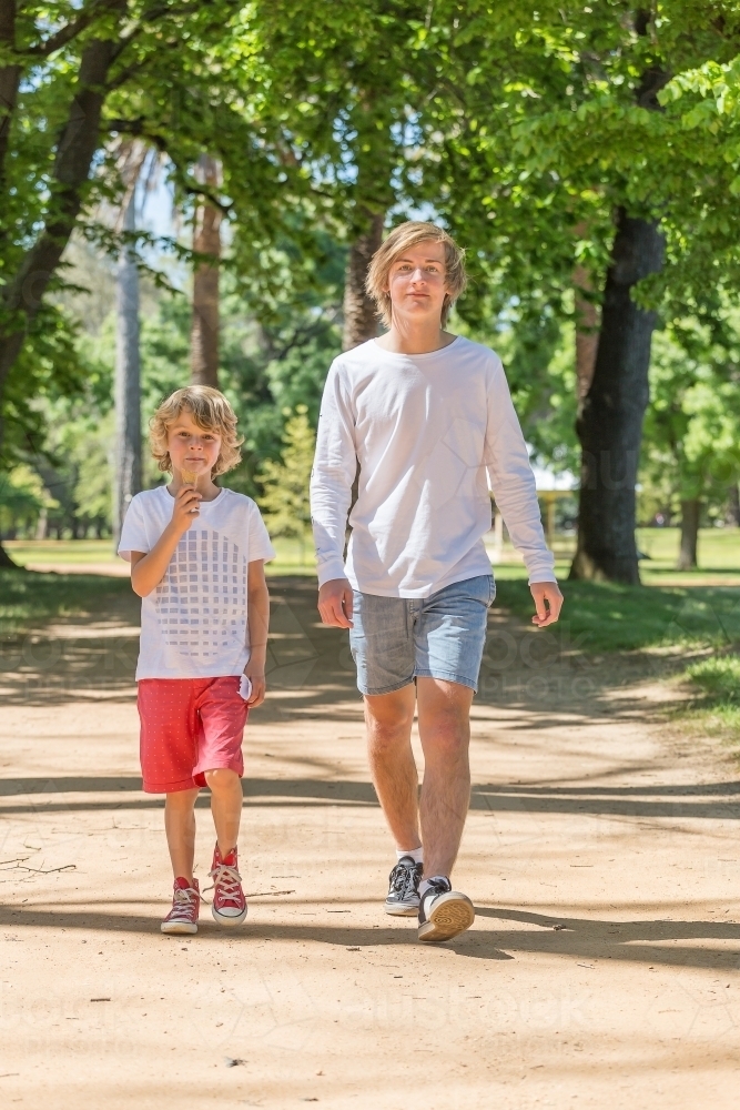 Two brothers walking together in a park - Australian Stock Image