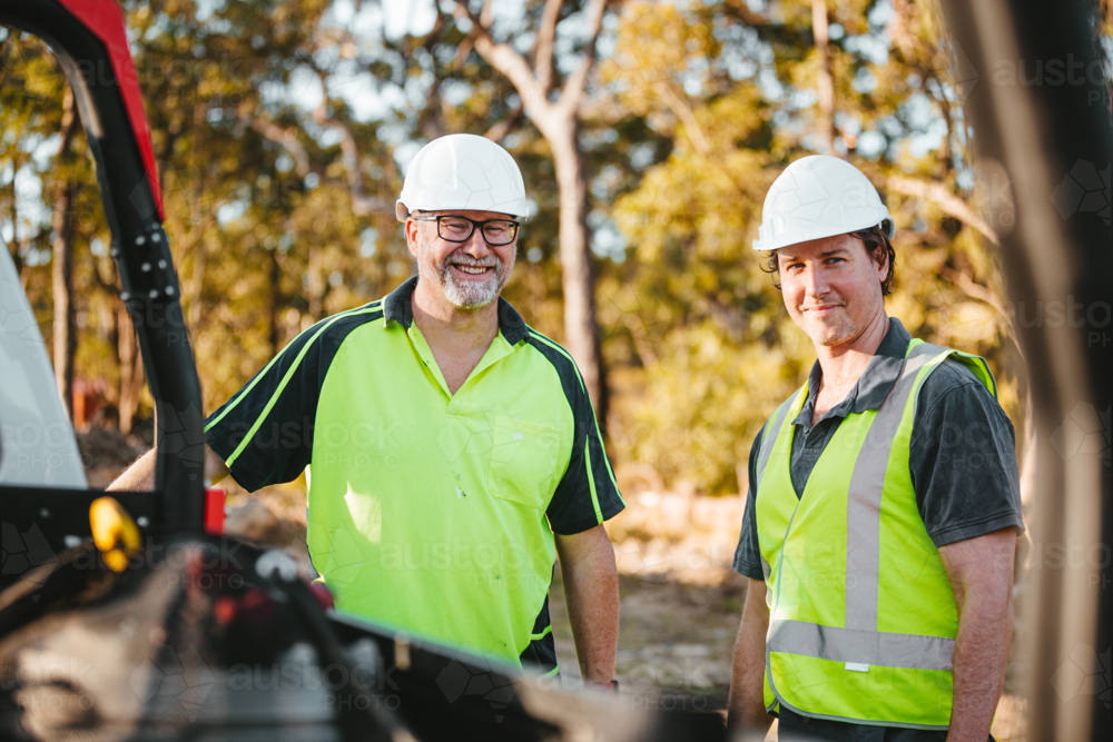 Two builders standing next to ute on worksite - Australian Stock Image