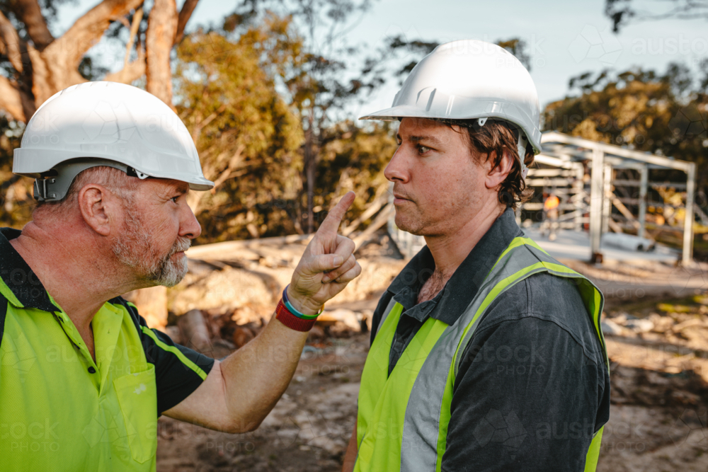 Two building contractors in a heated argument at the construction site. - Australian Stock Image