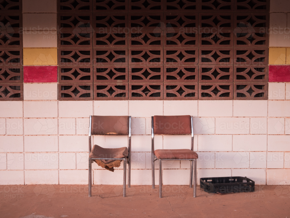 Two chairs in front of the tiled wall of a deserted building in outback Australia - Australian Stock Image