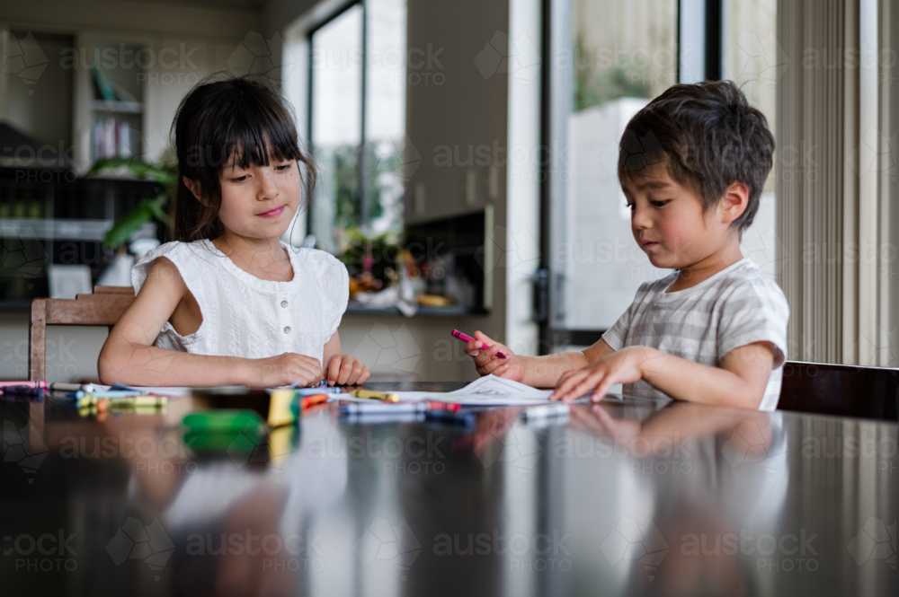 Image of Two children engaged in creative drawing activities at a ...