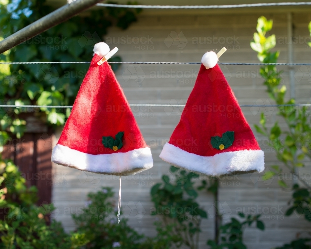 Two Christmas hats drying on the washing line - Australian Stock Image