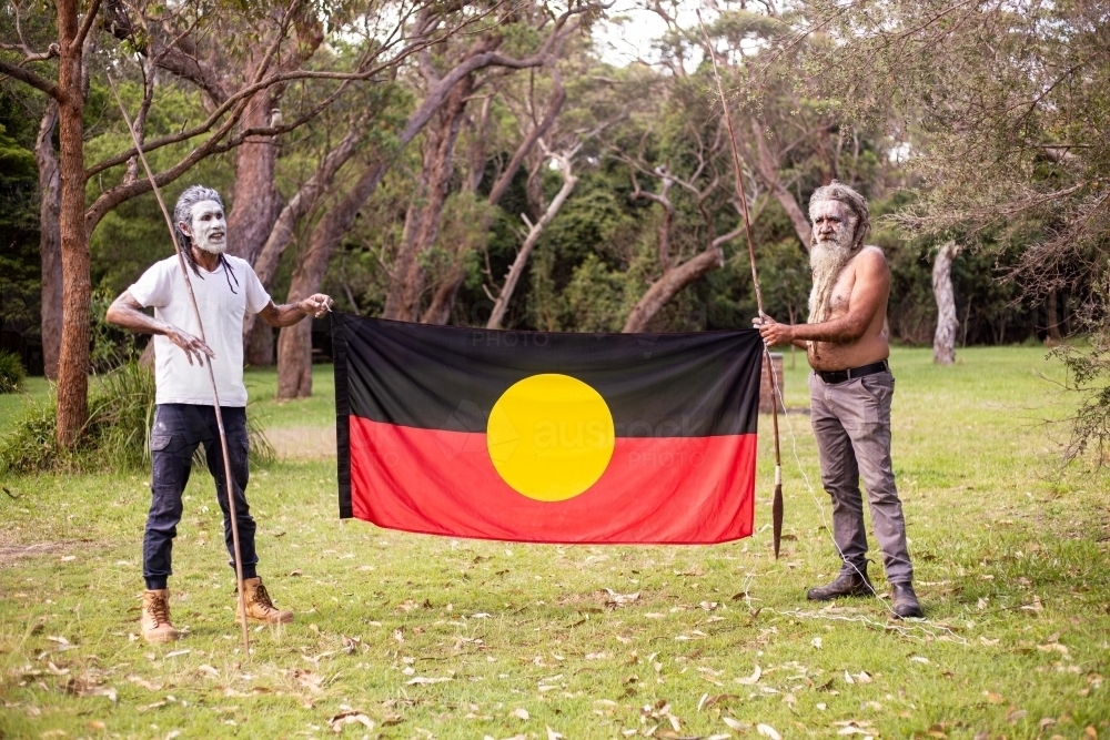 Two dharawal men holding the Australian aboriginal flag - Australian Stock Image