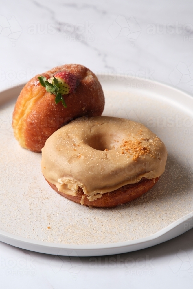 two donuts on a plate with fresh strawberry and sugar glaze - Australian Stock Image