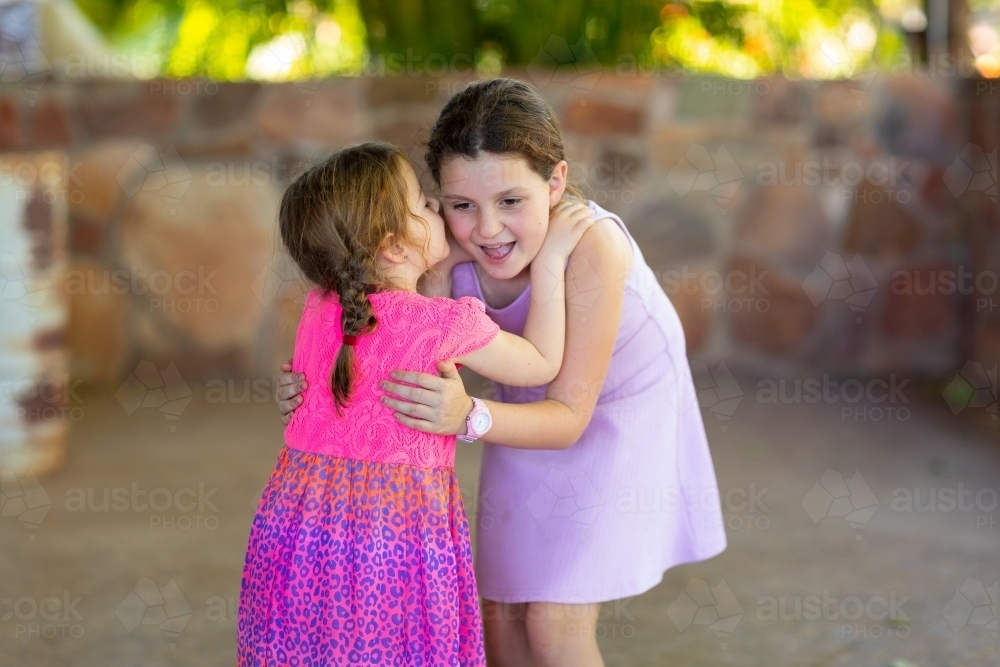 two female girls whispering and smiling - Australian Stock Image
