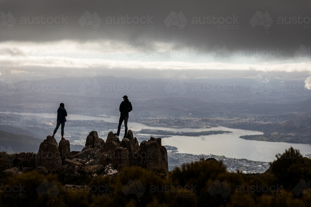Two figures on a mountain top in the clouds - Australian Stock Image