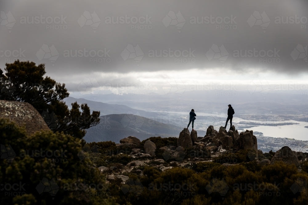 Two figures on a mountain top in the clouds - Australian Stock Image