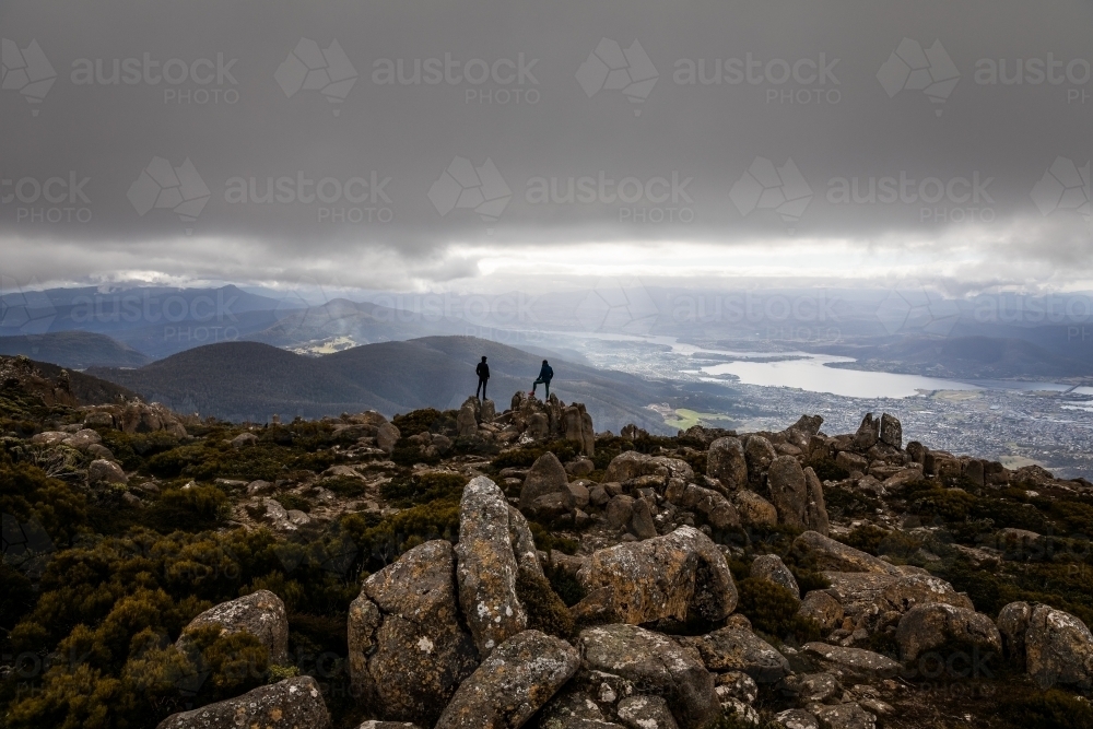 Two figures on a mountain top in the clouds - Australian Stock Image