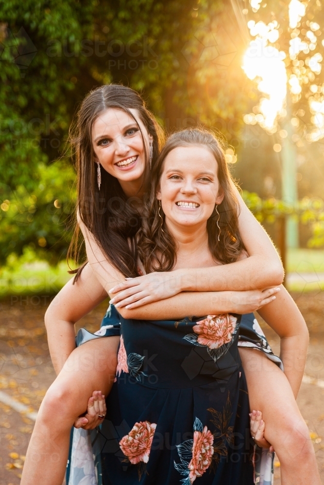 Two friends being silly together laughing in afternoon light - Australian Stock Image