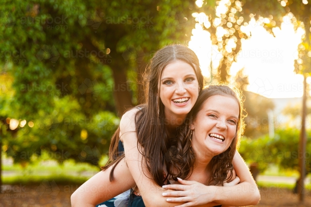 Two friends being silly together laughing in afternoon light - Australian Stock Image