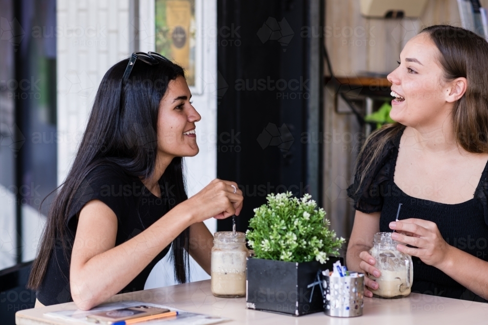 two friends chatting in a cafe - Australian Stock Image