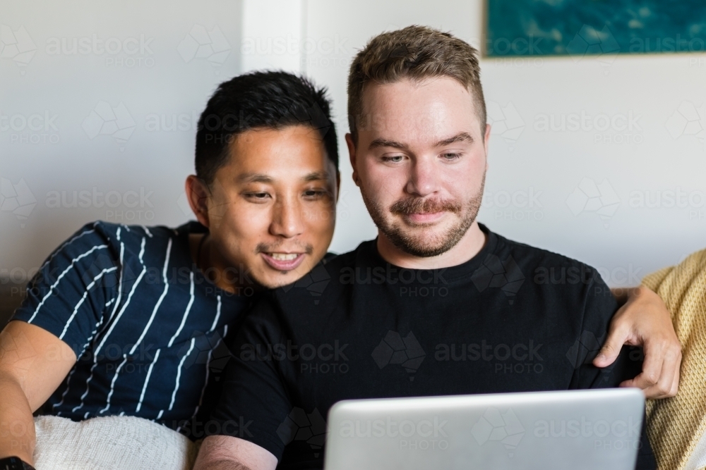 Two gay men using computer - Australian Stock Image