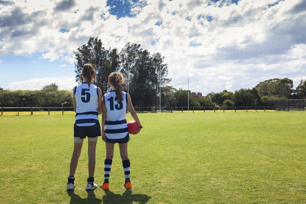 Two girl AFL players standing on the football ground - Australian Stock Image
