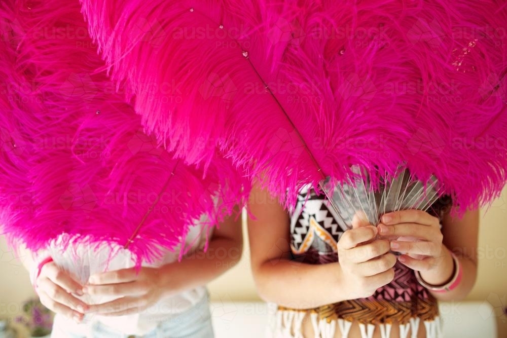 Two girls holding feather fans - Australian Stock Image