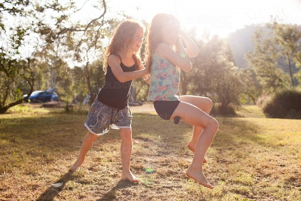 Two girls playing on a swing - Australian Stock Image