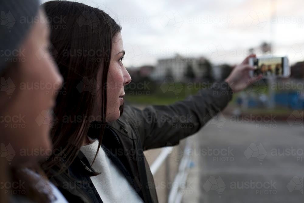 Two girls taking a selfie on the iphone - Australian Stock Image