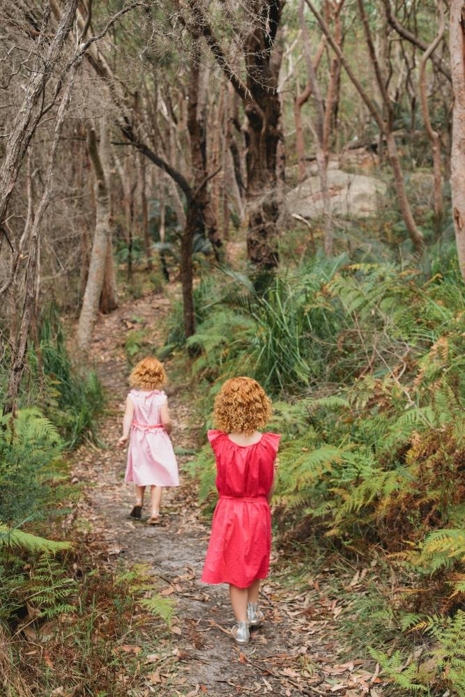 Two girls walking along a bush track - Australian Stock Image