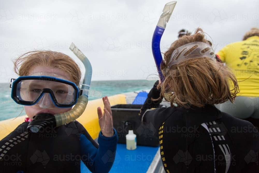 Two girls wearing masks, snorkels and wet suits - Australian Stock Image