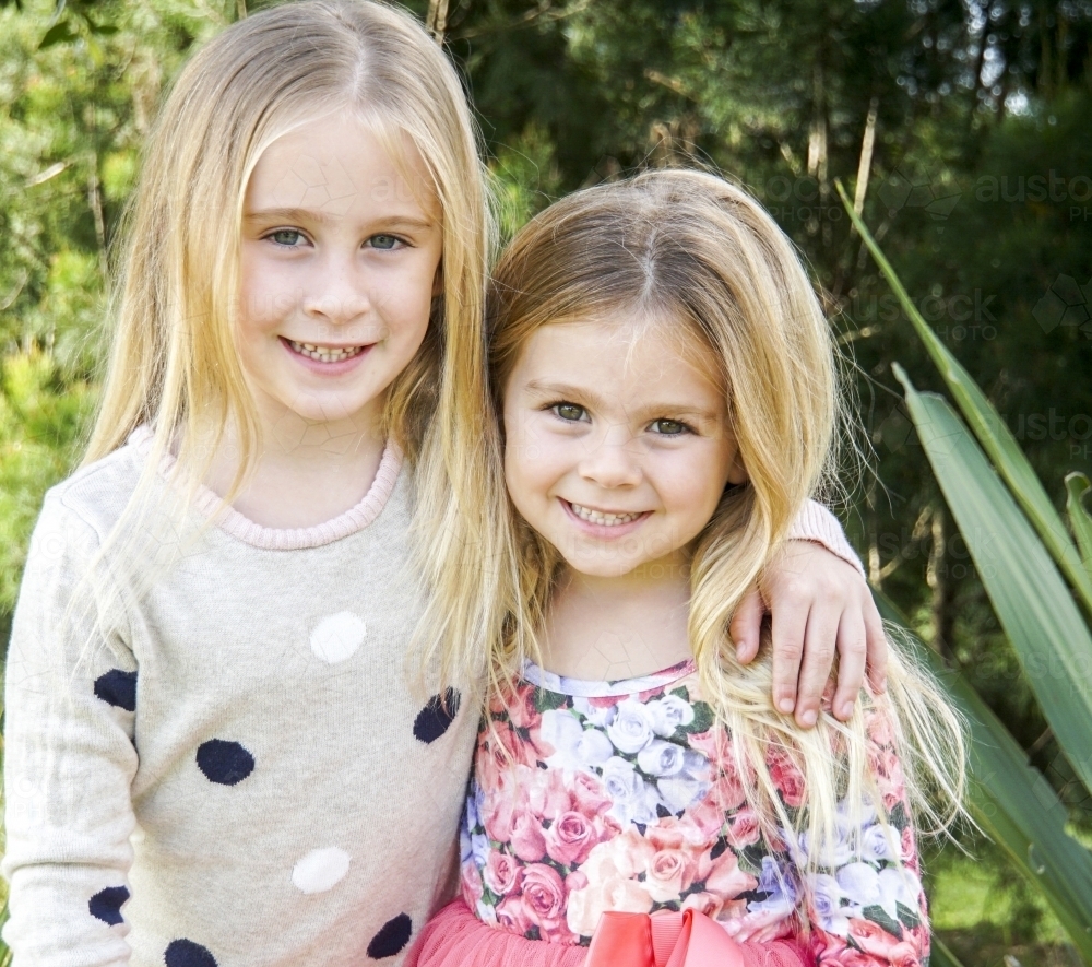Two girls with arms around each other - Australian Stock Image