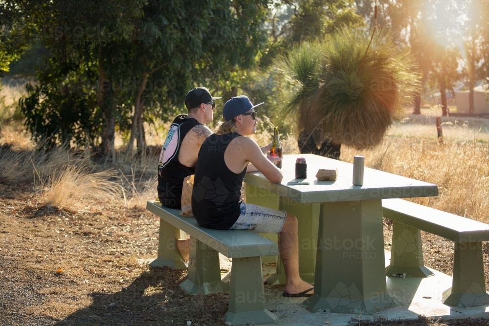 Two guys outdoors in the sunshine, with alcohol - Australian Stock Image