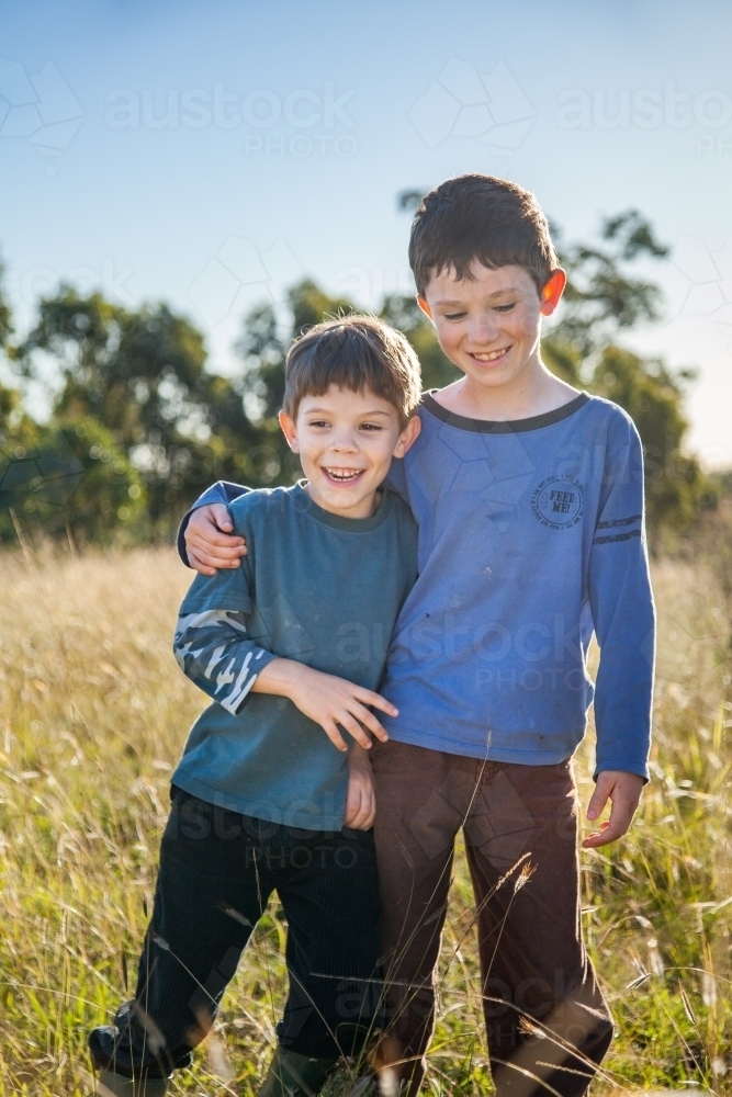 Two happy boys being kids together outdoors - Australian Stock Image