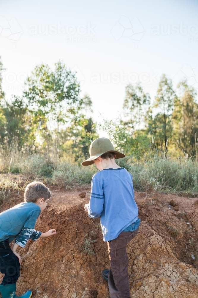 Image of Two happy boys playing in the dirt outside - Austockphoto