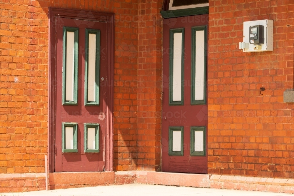 Two heritage style doors in the corner of a brick building - Australian Stock Image