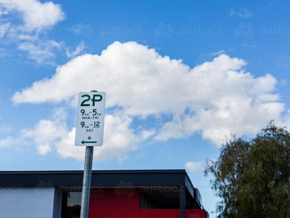 Two hour parking sign with blue sky and white clouds - Australian Stock Image