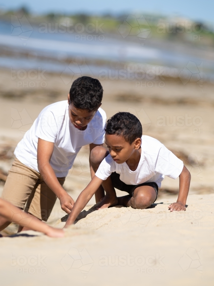 Two indigenous boys playing in the sand - Australian Stock Image