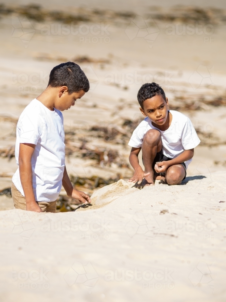 Two indigenous boys playing in the sand - Australian Stock Image