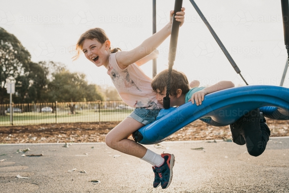 two kids on swing - Australian Stock Image