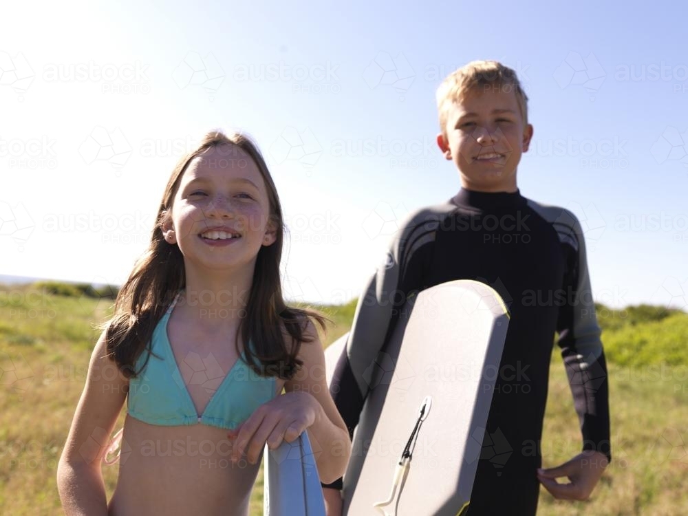 Two kids preparing to go body boarding - Australian Stock Image