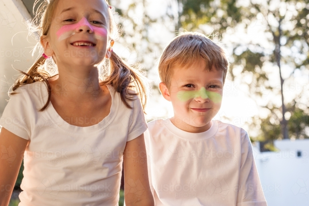 Two kids with zinc on their noses in the afternoon light - Australian Stock Image