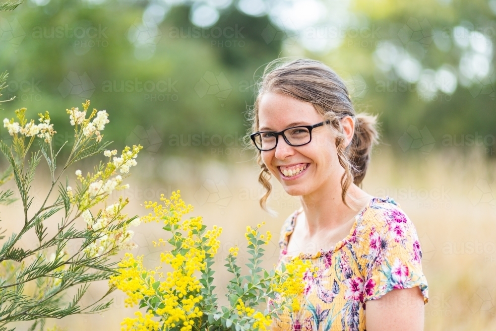 Two kinds of wattle blossoms and happy smiling woman - Australian Stock Image