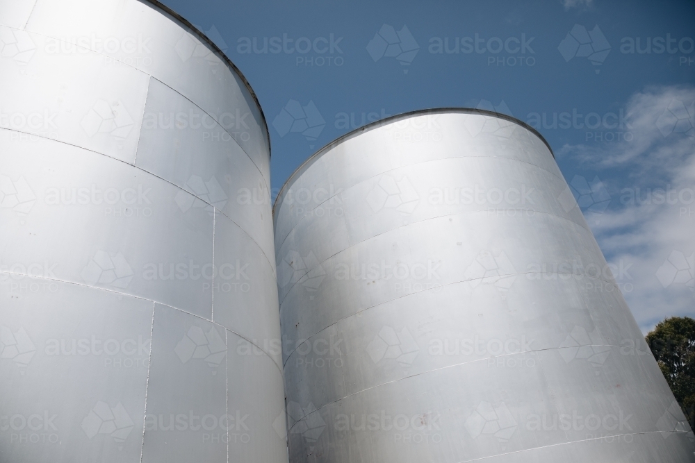 Two large, cylindrical storage tanks with a flat top. - Australian Stock Image