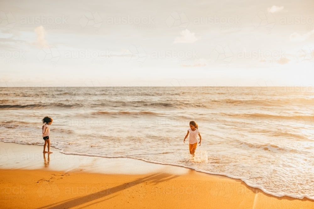 two little girls splashing at the beach - Australian Stock Image