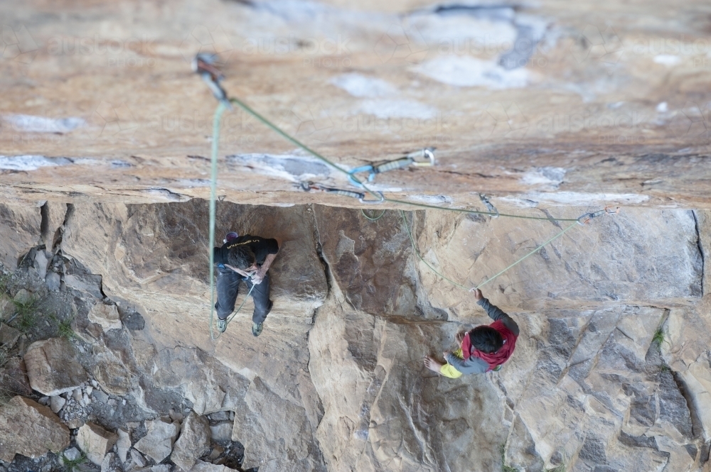 Two male rock climbers below route - Australian Stock Image