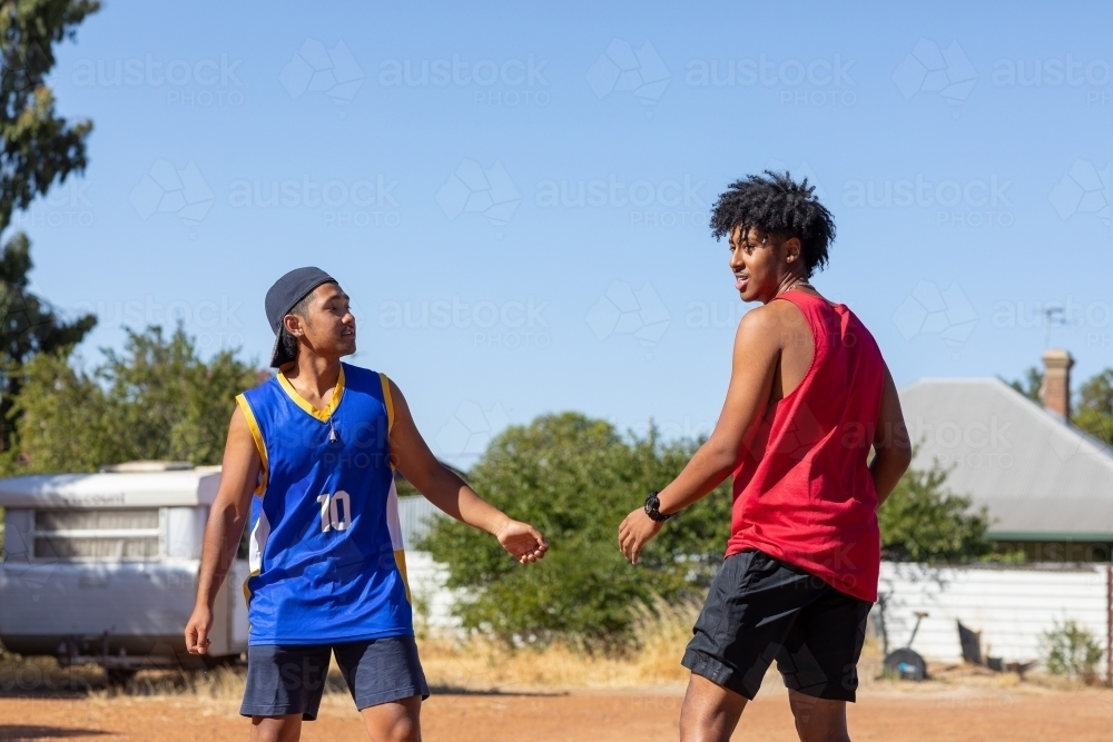 two mates facing up to each other in vacant lot - Australian Stock Image